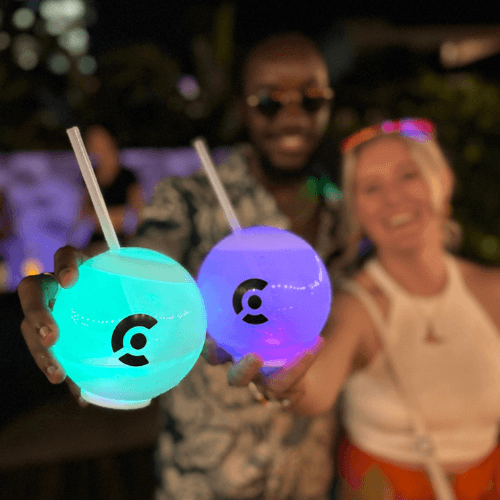 A man and a woman holding two glowing balls