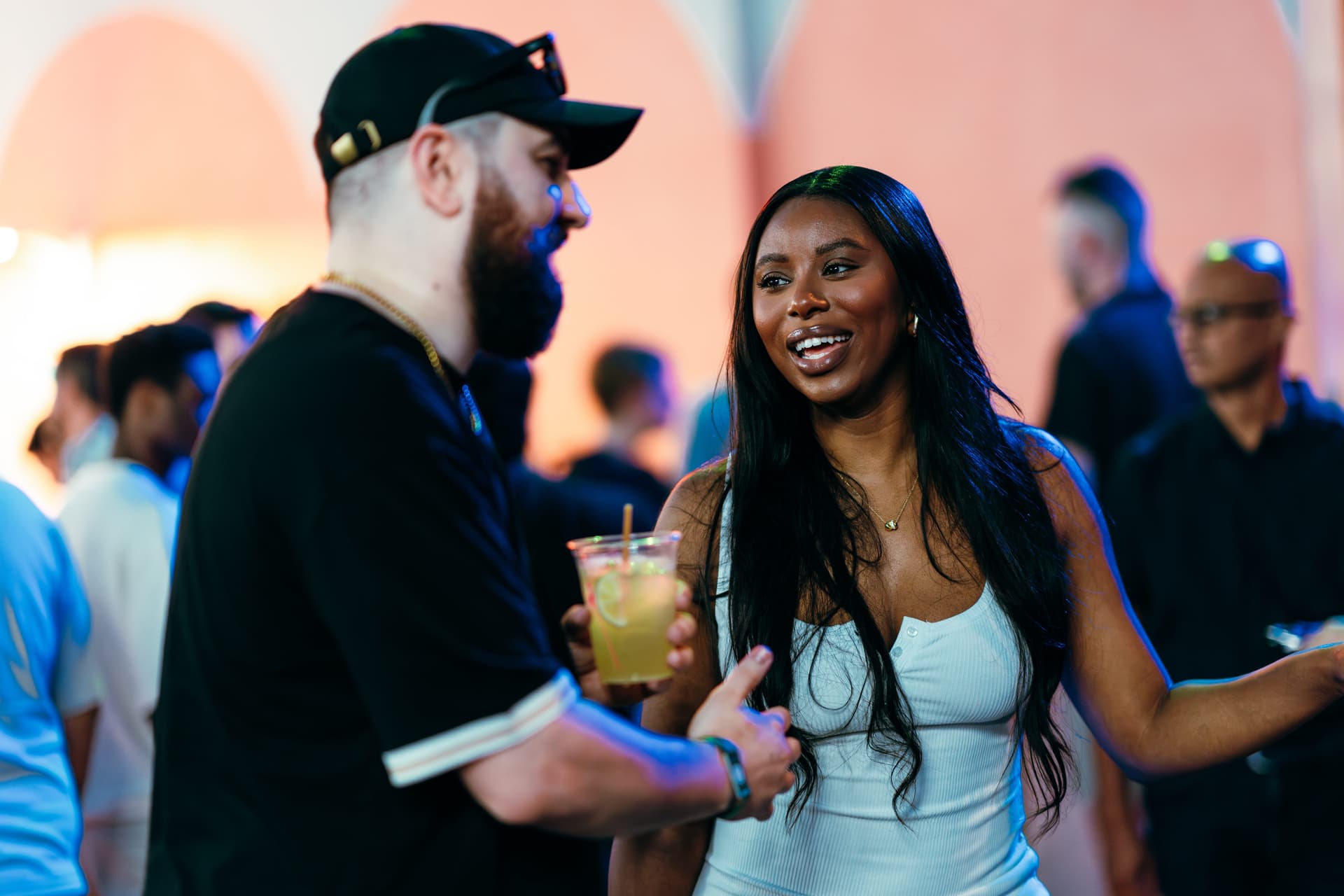 A man standing next to a woman holding a drink