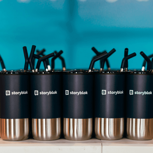 A row of black and silver coffee mugs sitting on top of a counter