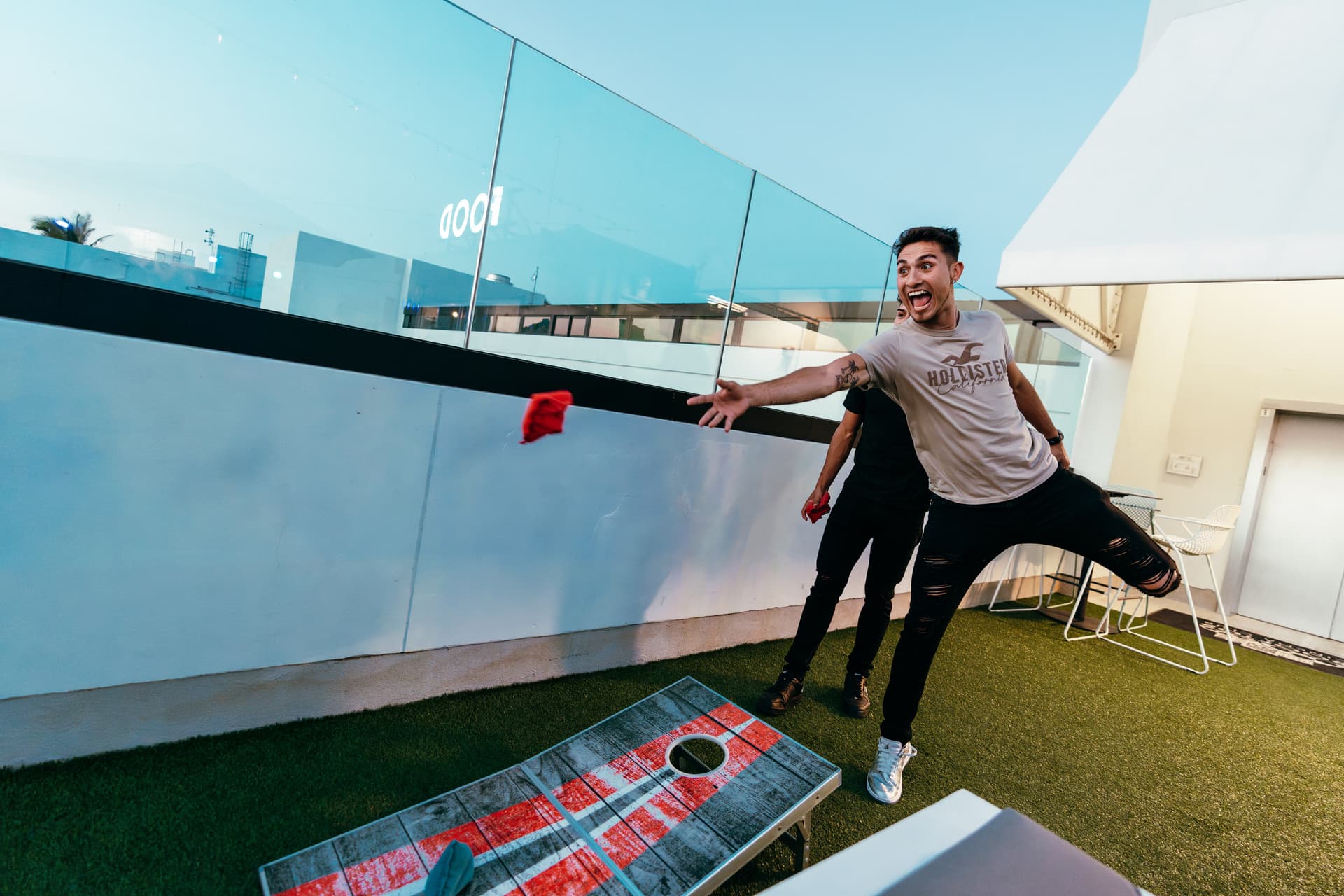 A man is playing a game of bean bag toss