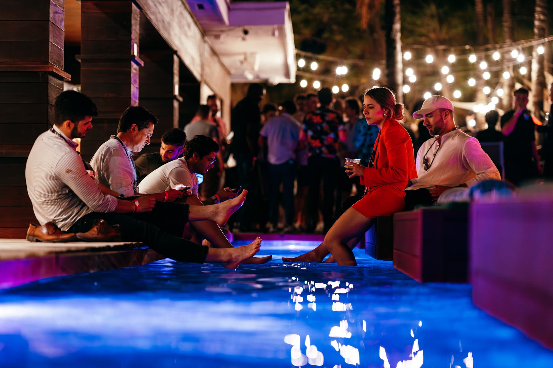 A group of people sitting next to a pool of water